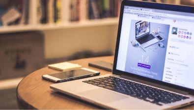 Un ordinateur portable ouvert, montrant un site web, est posé sur une table